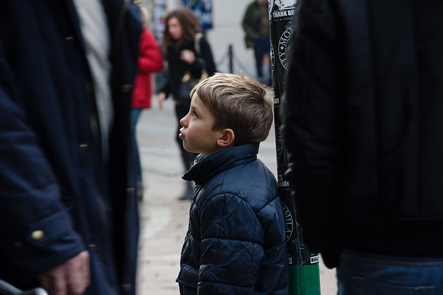 Träumender Junge in einer Einkaufsstraße in Mailand